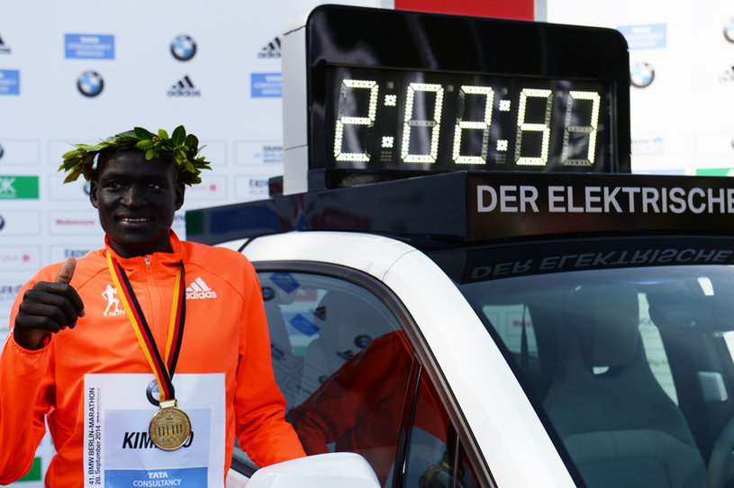 Dennis Kimetto ao lado de seu recorde mundial, conquistado na Maratona de Berlim Foto: Divulgação Facebook